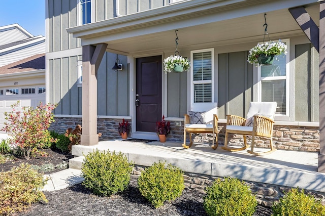 entrance to property featuring a porch, board and batten siding, and stone siding