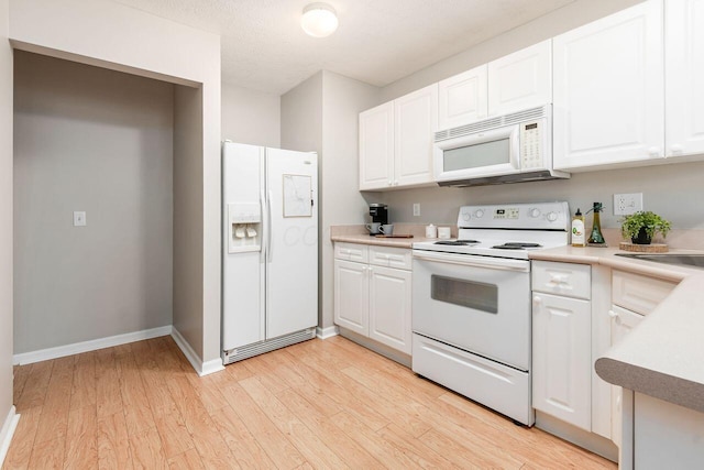 kitchen with white appliances, light countertops, white cabinets, and light wood-type flooring