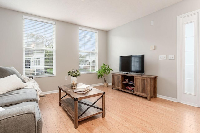 living room with baseboards and light wood-style flooring
