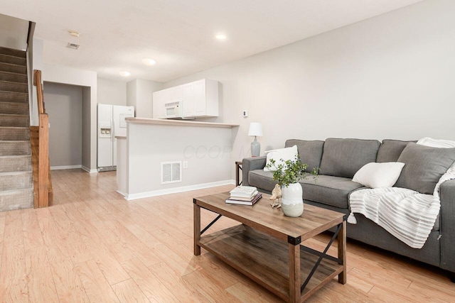 living area featuring visible vents, light wood-type flooring, stairs, baseboards, and recessed lighting