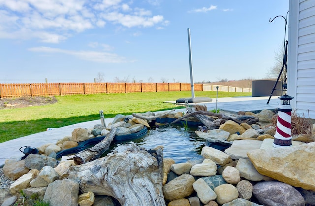 view of yard with a small pond and fence