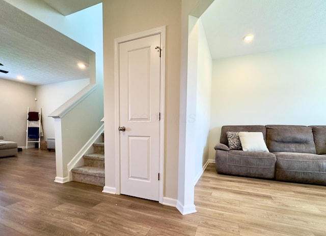 sitting room with recessed lighting, baseboards, stairs, and wood finished floors