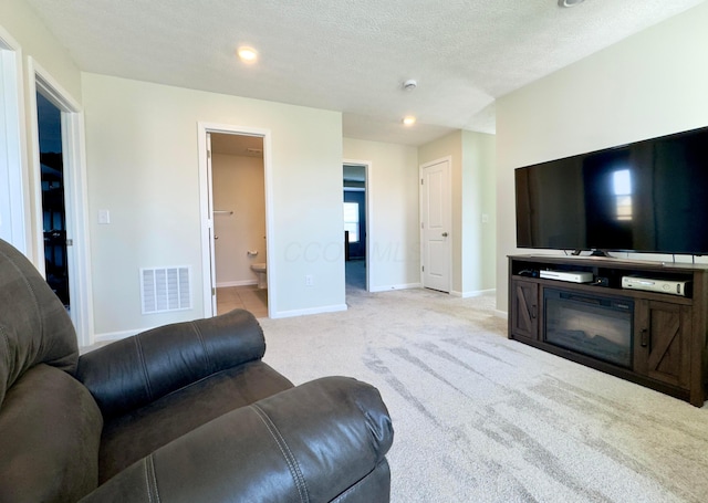 living room featuring a textured ceiling, visible vents, baseboards, carpet, and recessed lighting
