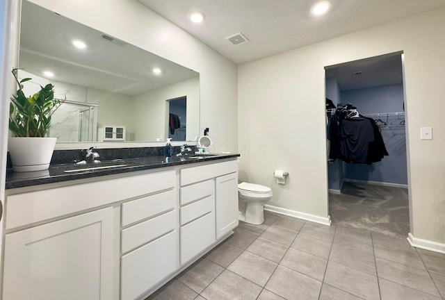 full bath featuring a sink, double vanity, baseboards, a shower stall, and visible vents