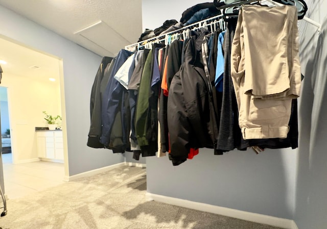 spacious closet with attic access and carpet flooring