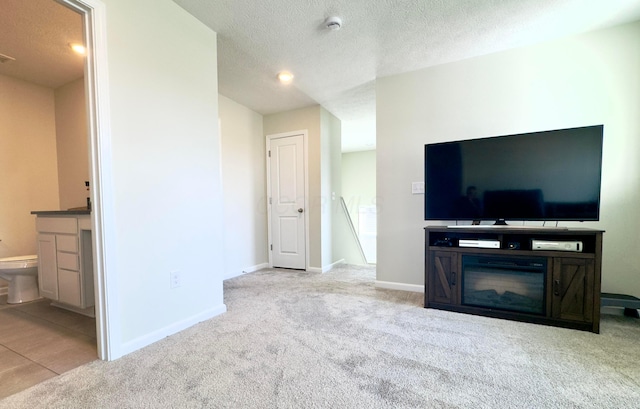 unfurnished living room with baseboards, carpet flooring, and a textured ceiling