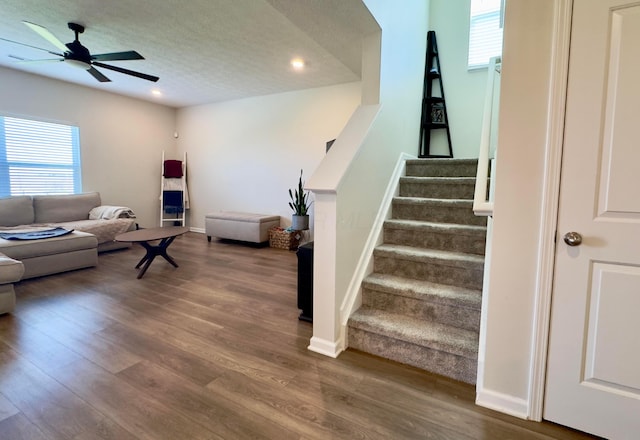 living area with stairs, wood finished floors, recessed lighting, a textured ceiling, and a ceiling fan