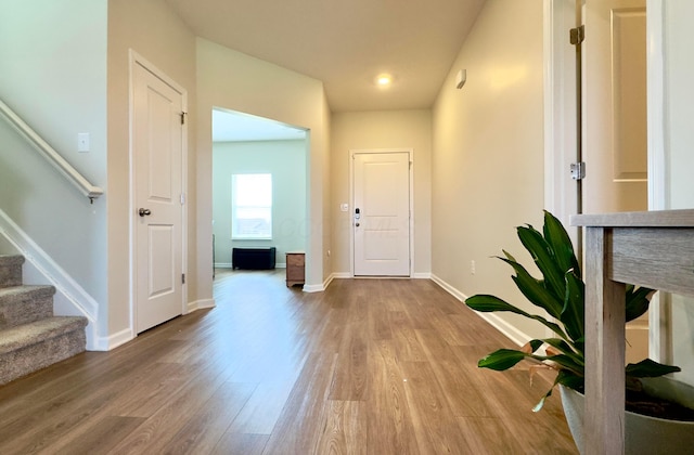 entrance foyer with stairway, baseboards, and wood finished floors
