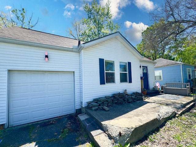 view of front facade featuring a garage, aphalt driveway, and a shingled roof