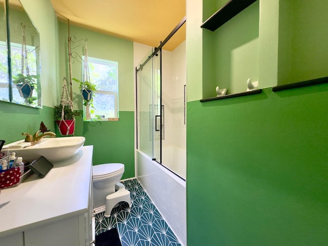 bathroom with toilet, bath / shower combo with glass door, and vanity