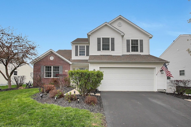 traditional-style house featuring a garage, a shingled roof, a front yard, and aphalt driveway
