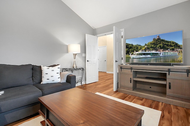 living room featuring wood finished floors and lofted ceiling