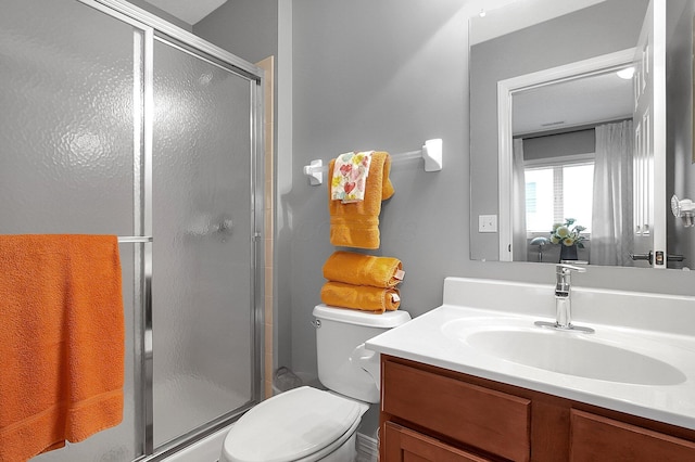 bathroom with vanity, a stall shower, and toilet