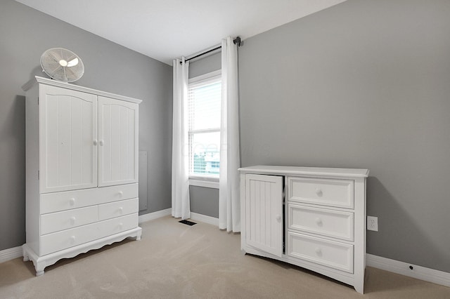 bedroom with baseboards, multiple windows, and light carpet
