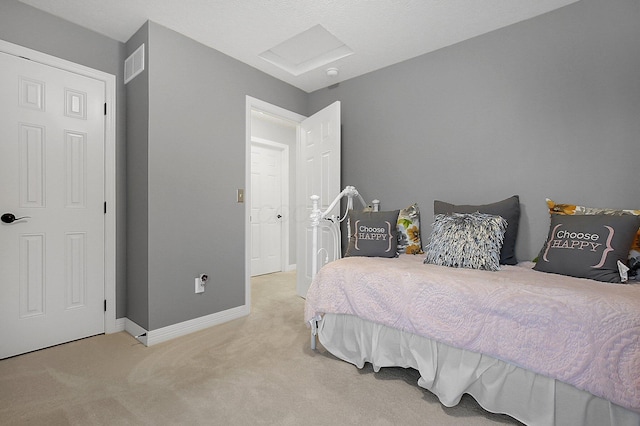 carpeted bedroom with visible vents, attic access, and baseboards