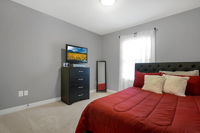 bedroom featuring baseboards and light colored carpet