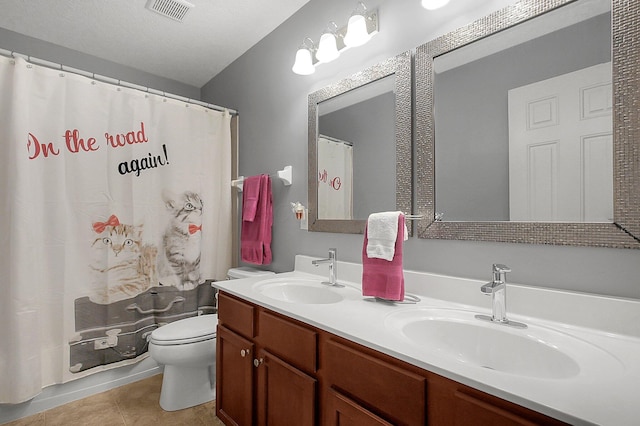 bathroom with toilet, visible vents, a sink, and tile patterned flooring