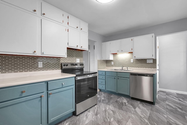 542 E Franklin St, Circleville, OH 43113 - kitchen with light countertops, white cabinets, a sink, backsplash, and stainless steel appliances