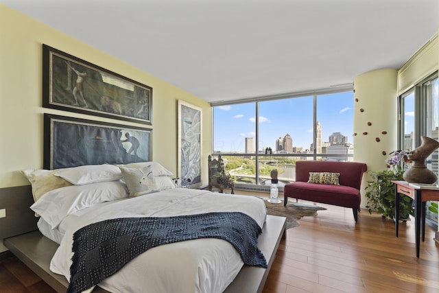 1 Miranova Pl Unit 1505, Columbus, OH 43215 - bedroom with a skyline view, wood-type flooring, and floor to ceiling windows