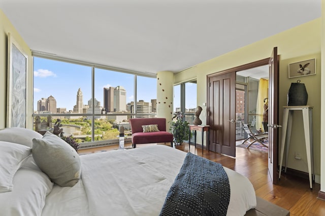 1 Miranova Pl Unit 1505, Columbus, OH 43215 - bedroom featuring a skyline view and hardwood / wood-style flooring