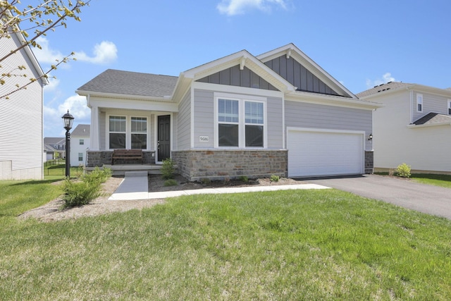 craftsman-style home with aphalt driveway, board and batten siding, a front yard, and stone siding