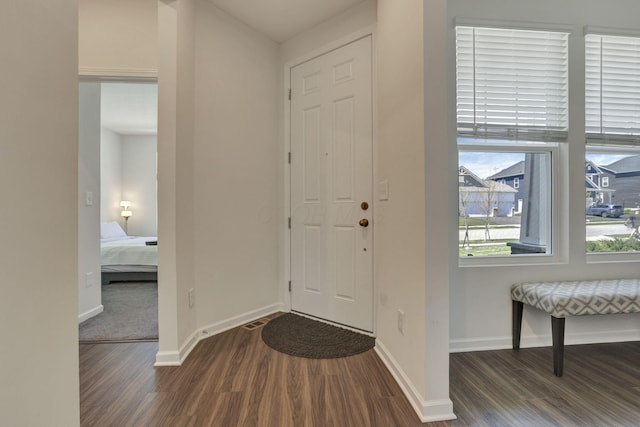 foyer featuring baseboards and dark wood-style flooring