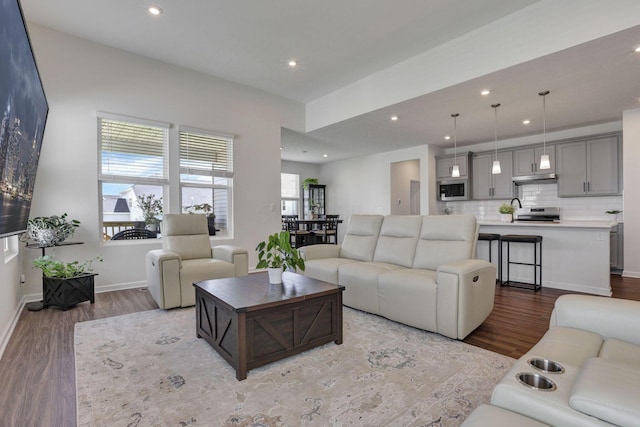 living room featuring baseboards, recessed lighting, and wood finished floors