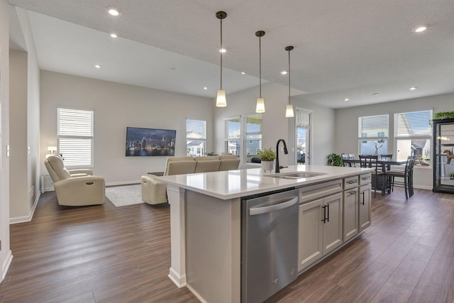 kitchen featuring baseboards, open floor plan, dark wood-type flooring, a sink, and dishwasher
