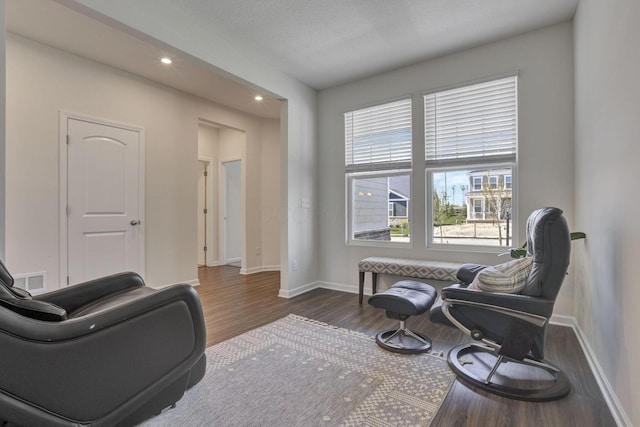 living area with baseboards, recessed lighting, wood finished floors, and visible vents