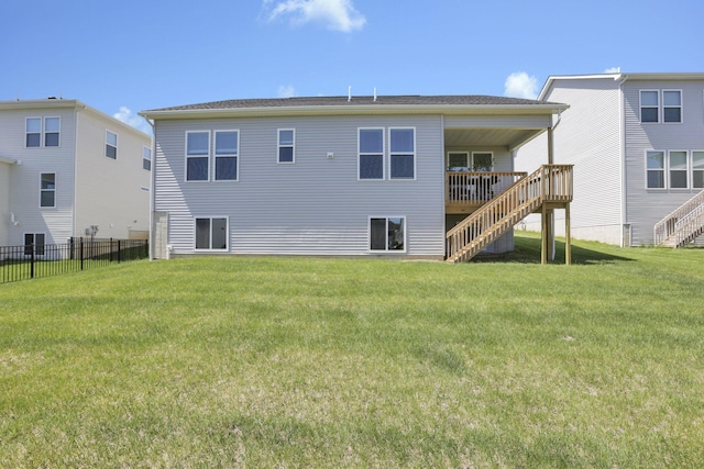 rear view of house with fence, stairs, a yard, and a wooden deck