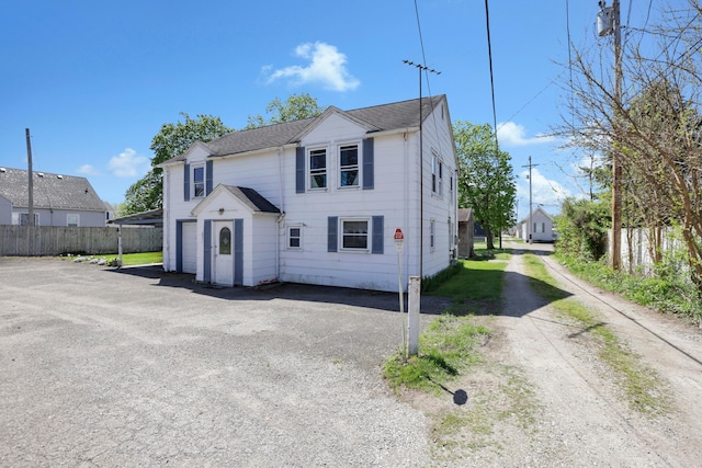 view of front of property featuring aphalt driveway and fence