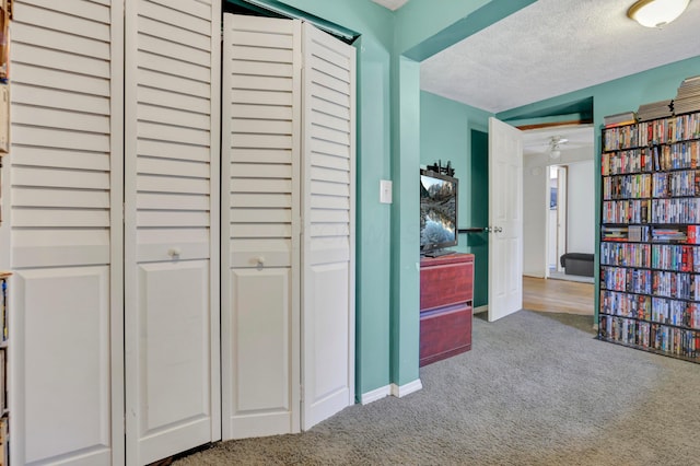 interior space featuring baseboards, carpet, and a textured ceiling