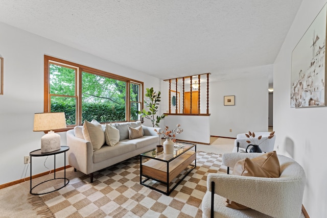 living room with a textured ceiling, baseboards, and light carpet