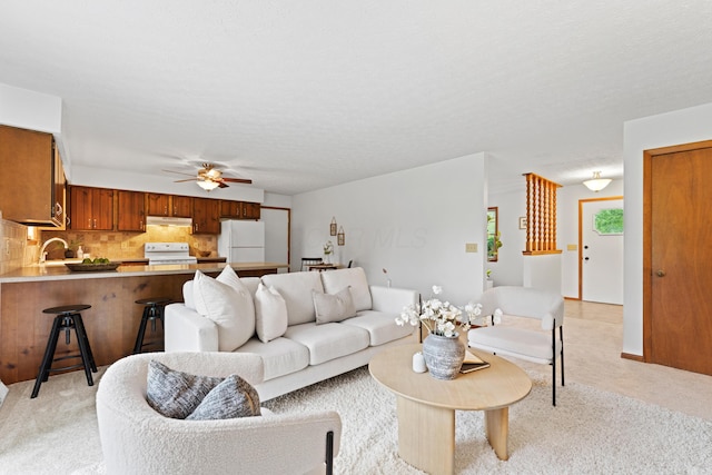 living area with ceiling fan and light colored carpet