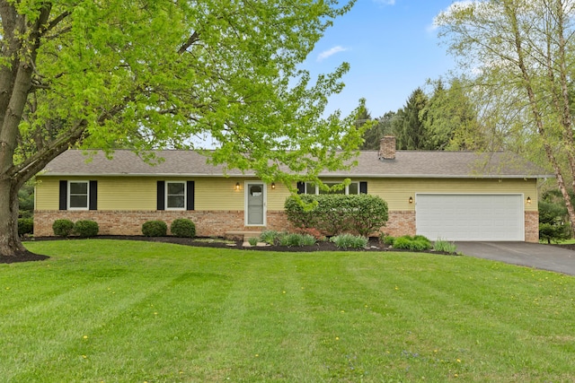 ranch-style house featuring brick siding, a garage, a front lawn, and driveway