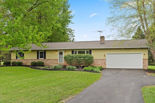 single story home with a front yard, a chimney, brick siding, an attached garage, and driveway