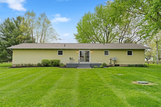 rear view of property featuring a lawn and central air condition unit