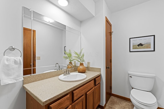 bathroom with vanity, baseboards, tile patterned floors, and toilet
