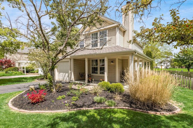 view of front of house featuring fence, a chimney, driveway, and a front lawn