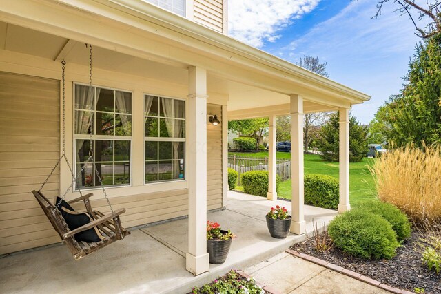 view of patio / terrace with fence and a porch
