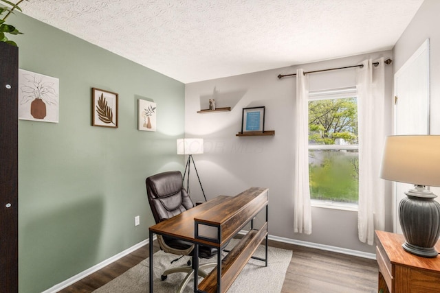 office space featuring baseboards, a textured ceiling, and wood finished floors