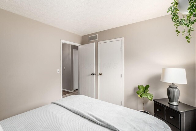 bedroom featuring a textured ceiling and visible vents