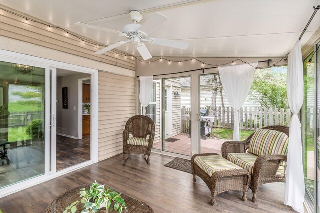 sunroom / solarium featuring rail lighting, ceiling fan, and an outdoor living space