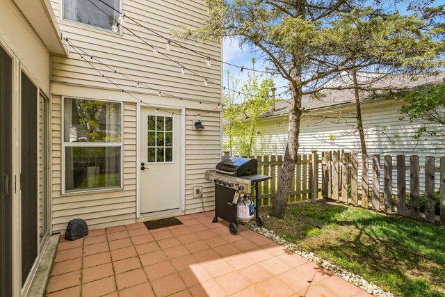 view of patio with fence and a grill