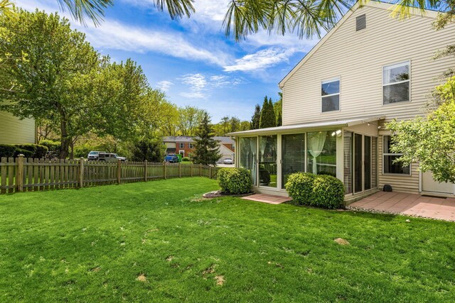 view of yard with fence and a sunroom