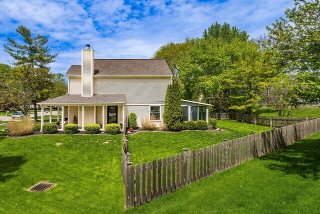 view of front of home featuring fence, a shingled roof, a front lawn, a chimney, and covered porch
