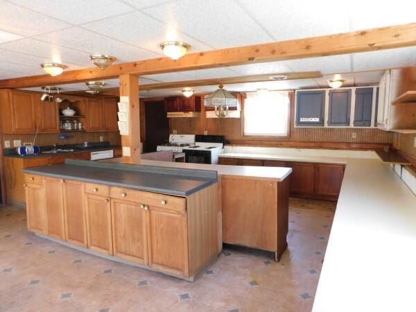 kitchen with white stove, open shelves, a kitchen island, and dark countertops