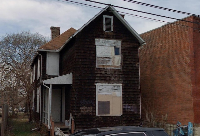 view of front facade with fence and a chimney