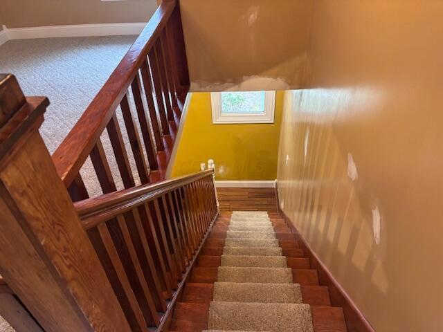 stairs featuring baseboards and wood finished floors