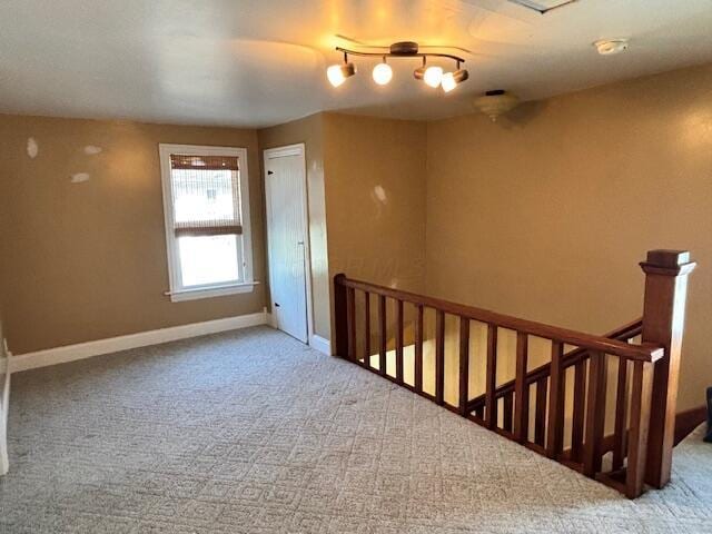 carpeted empty room with baseboards